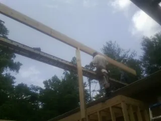Carpenter setting a ridge beam over a new addition frame — Ice Dam Removal by Roofing Brothers in Topeka