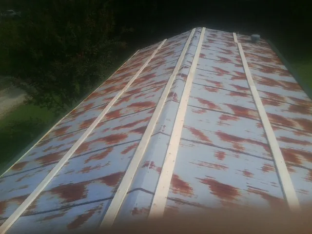 Rusted metal roof panels with new wood purlins before replacement — Storm Damage Roof Repair in Topeka by Roofing Brothers