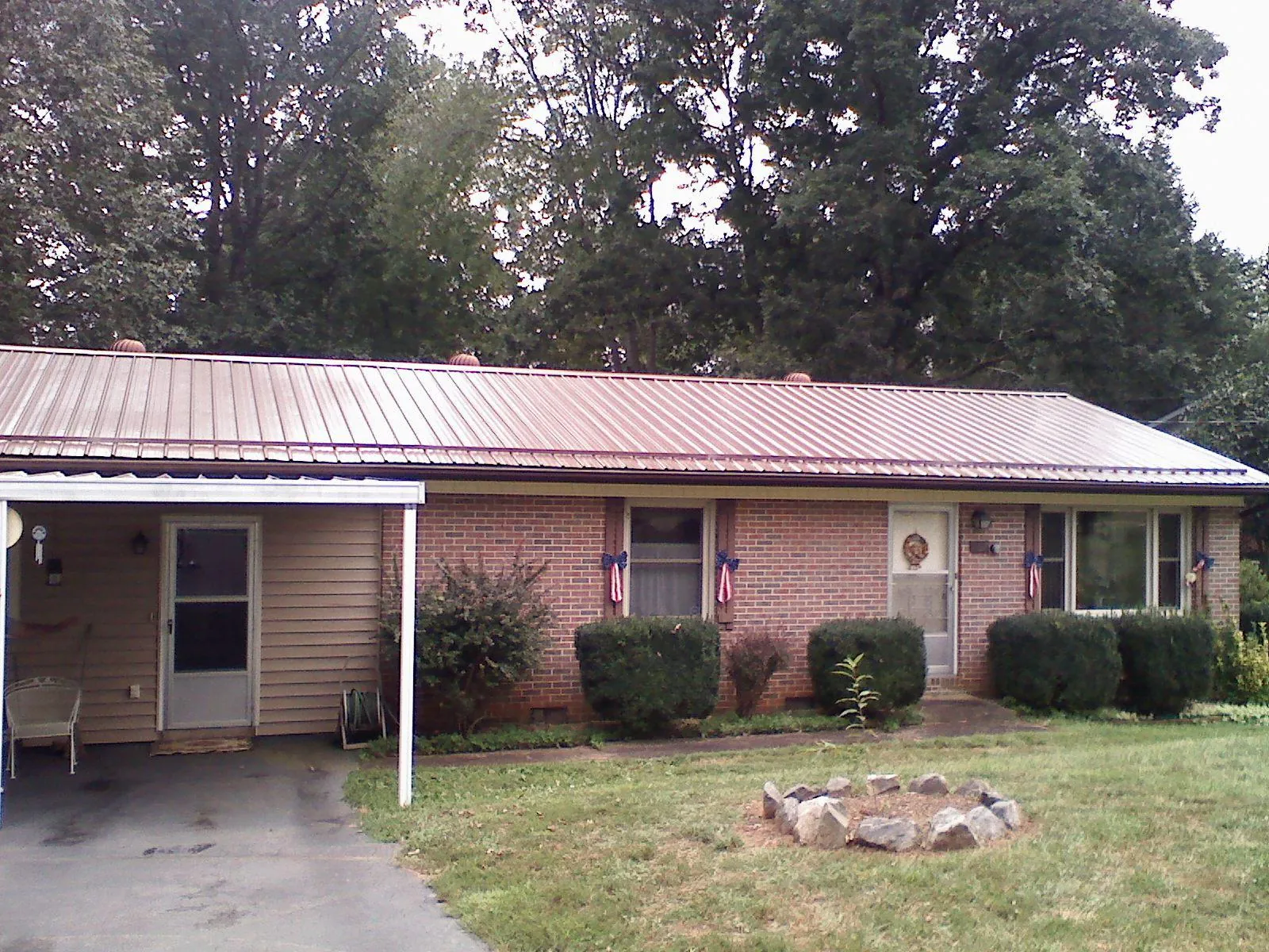 Bronze metal roof and carport on a brick ranch home — Roof Repair work by our crew in Topeka